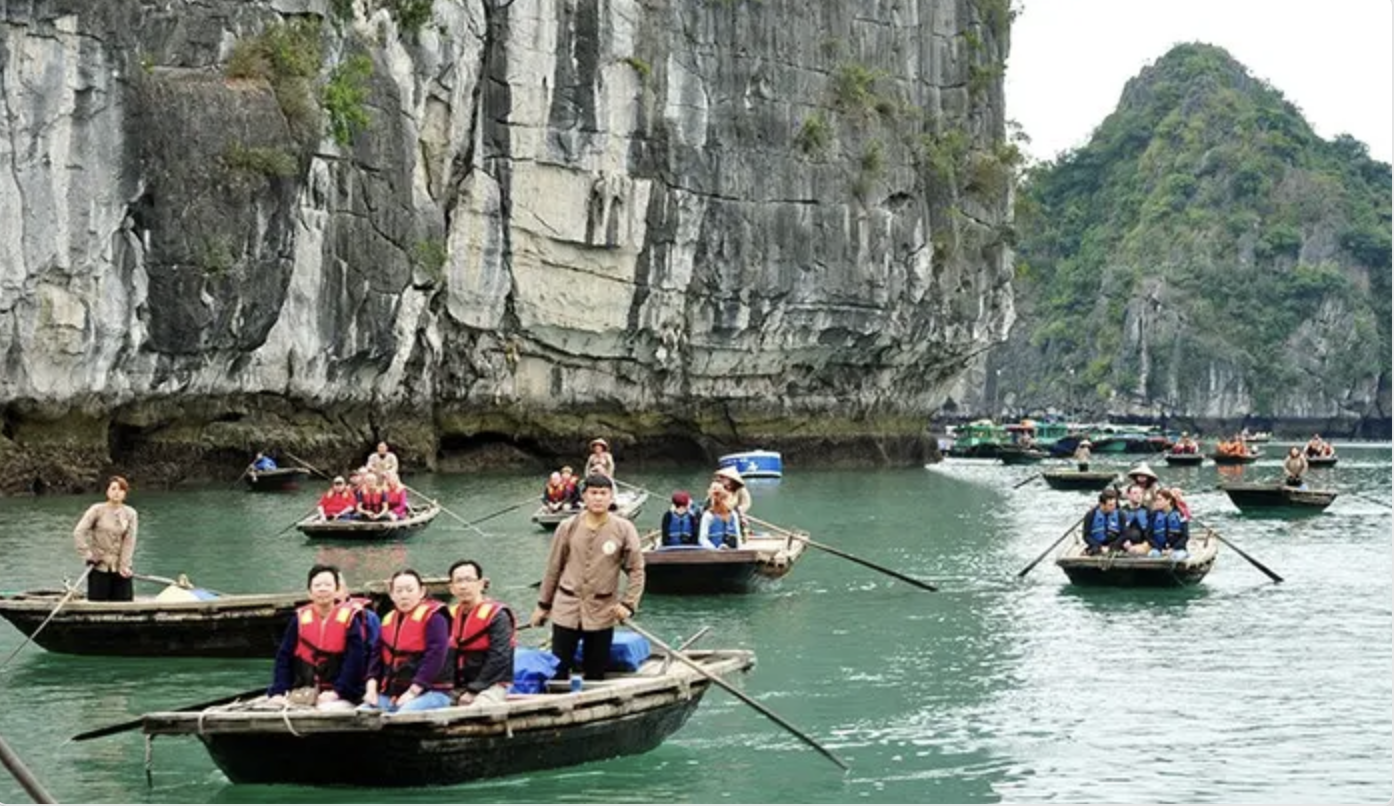Du khách hào hứng chèo thuyền để khám phá các hang luồn và cảnh quan thiên nhiên trên vịnh Hạ Long 